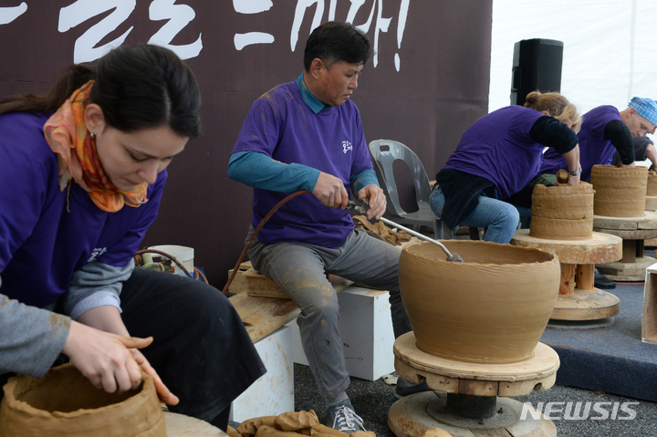 [울산=뉴시스] 배병수 기자 = 2023 울산 옹기축제가 열리고 있는 7일 오전 울주군 외고산 옹기마을 문화박물관앞에서 이마을 옹기장인과 외국인들이 옹기 만드는 체험을 하고 있다. 2023.05.07. bbs@newsis.com
