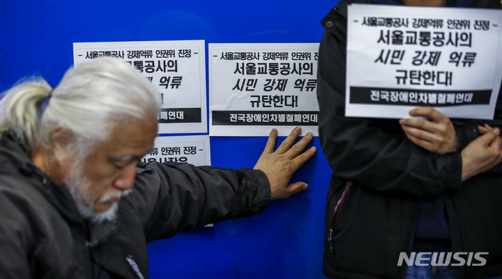 [서울=뉴시스] 정병혁 기자 = 박경석 전국장애인차별철폐연대 상임공동대표가 8일 오전 서울 중구 을지로3가역에서 열린 장애인 권리스티커 부착, 서울교통공사 강제억류 인권위원회 진정 기자회견에서 승강장에 스티커를 붙이고 있다. 2023.05.08. jhope@newsis.com