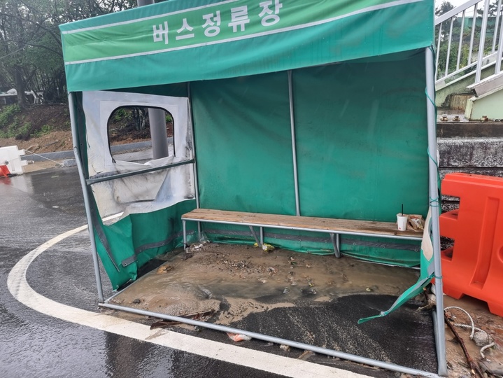 지난 5일 내린 비로 인해 양산시 동면 사송신도시 조성공사 구간의 부산방향 지방도에 있는 버스정류장이 토사와 모래 등 흙탕물이 뒤섞여 있다. (사진 = 양산뉴스파크 제공) *재판매 및 DB 금지