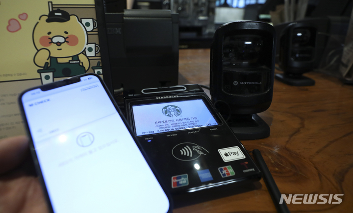 [서울=뉴시스] 최진석 기자 = 스타벅스 매장에서 애플페이(Apple Pay) 결제가 가능해진 9일 서울 한 스타벅스 매장 결제 단말기에 애플페이 스티커가 붙어 있다. 2023.05.09. myjs@newsis.com