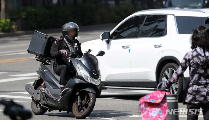 [서울=뉴시스] 김선웅 기자 = 배달라이더 노동조합이 처우 개선을 촉구하며 연쇄 파업 투쟁을 이어가는 가운데 9일 서울 시내에서 한 배달라이더가 오토바이를 운전하고 있다. 어린이날 파업과 10일로 예정된 국회 앞 오토바이 행진 등으로 배달 대란이 우려됐으나 실제 현장에는 영향이 미미했다는 것이 업계의 시선이다. 2023.05.09. mangusta@newsis.com