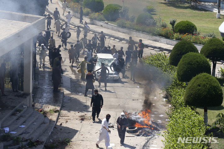 [페샤와르=AP/뉴시스] 10일(현지시각) 파키스탄 페샤와르에서 임란 칸 전 총리의 체포에 항의하는 시위대가 라디오 파키스탄 영내 차량을 파손하고 있다. 칸 전 총리는 체포된 지 하루 만에 법정에 출두했으며 법원은 전 총리에게 8일간의 구금을 선고했다. 2023.05.11.