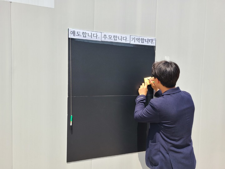 [수원=뉴시스] 양효원 기자 = 경기 수원시 권선구 금곡동 한 사거리에서 신호 위반 버스에 치어 사망한 초등학생을 위해 마련된 추모공간을 찾은 시민이 추모 메시지를 적고 있다. 2023.5.11. hyo@newsis.com *재판매 및 DB 금지