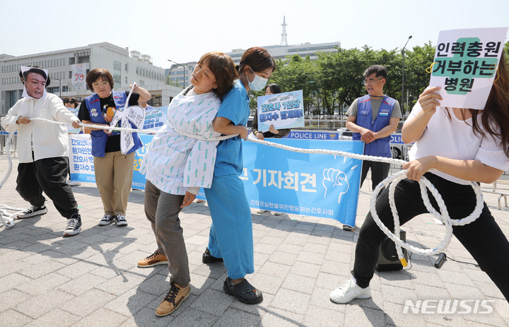 [서울=뉴시스] 김진아 기자 = 국제 간호사의 날을 하루 앞둔 11일 서울 용산구 대통령집무실 앞에서 민주노총 공공운수노조 의료연대본부 관계자들이 '간호사 1인당 담당 환자수 법제화'를 위한 간호인력인권법 제정 촉구 기자회견에서 인력충원 거부하는 정부 및 병원 규탄 퍼포먼스를 하고 있다. 2023.05.11. bluesoda@newsis.com