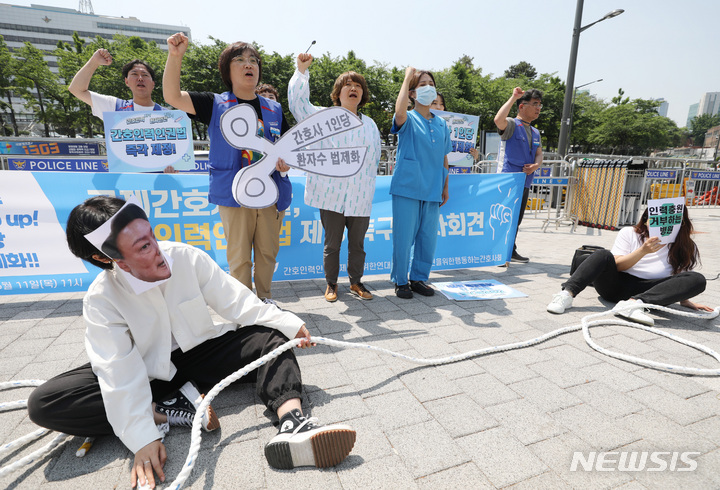 [서울=뉴시스] 김진아 기자 = 국제 간호사의 날을 하루 앞둔 11일 서울 용산구 대통령집무실 앞에서 민주노총 공공운수노조 의료연대본부 관계자들이 '간호사 1인당 담당 환자수 법제화'를 위한 간호인력인권법 제정 촉구 기자회견에서 인력충원 거부하는 정부 및 병원 규탄 퍼포먼스를 하고 있다. 2023.05.11. bluesoda@newsis.com