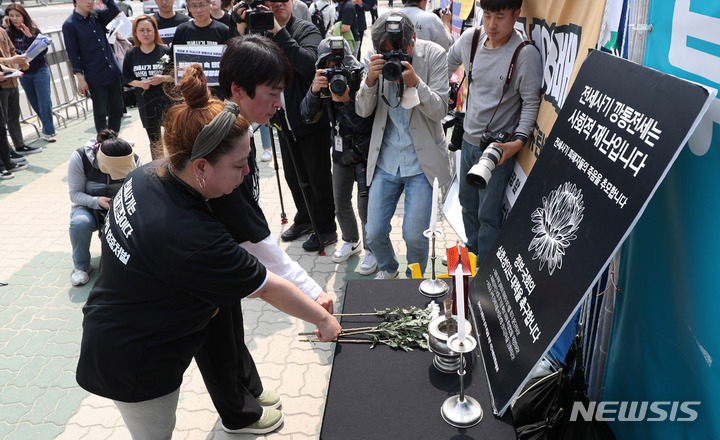 [서울=뉴시스] 추상철 기자 = 11일 오후 서울 여의도 국회 앞에서 열린 전세사기 깡통전세 특별법 제정 촉구 기자회견에서 참가자가 피해자의 죽음을 추모하는 헌화를 하고 있다. 2023.05.11. scchoo@newsis.com