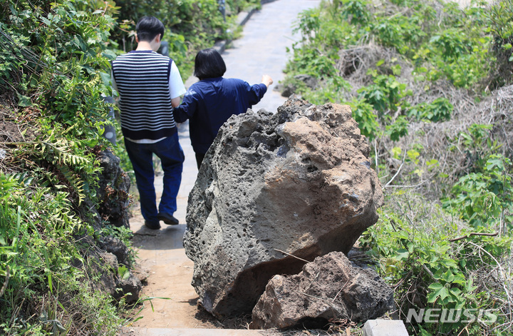 [제주=뉴시스] 우장호 기자 = 관광객들이 11일 오후 제주시 애월읍 한담해안 산책로에 떨어진 커다란 바위 옆으로 걸어가고 있다. 관광객들이 많이 찾는 대표 관광지인 한담해안산책로는 2016년과 2021년에도 낙석 사고가 발생해 출입 통제가 이뤄진 바 있다. 2023.05.11. woo1223@newsis.com