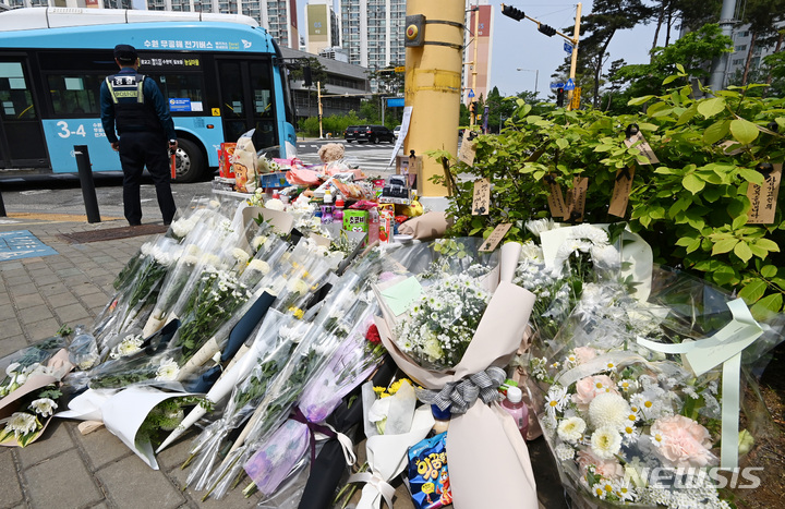 [수원=뉴시스] 김종택 기자 = 11일 경기도 수원시 권선구의 한 사거리에 전날 어리이보호구역(스쿨존)에서 시내버스에 치여 숨진 초등학생을 추모하는 추모 물품들이 놓여 있다. 2023.05.11. jtk@newsis.com