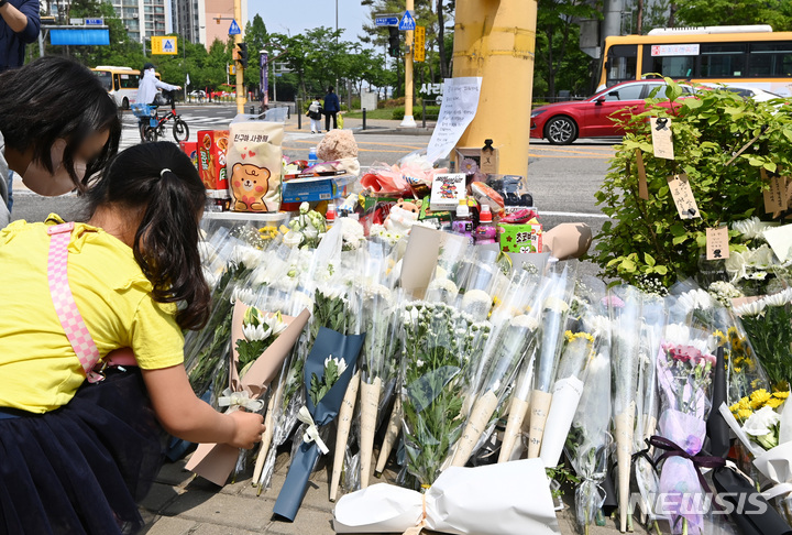 [수원=뉴시스] 김종택 기자 = 11일 경기도 수원시 권선구의 한 사거리에 전날 어리이보호구역(스쿨존)에서 시내버스에 치여 숨진 초등학생을 추모하는 추모 물품들이 놓여 있다. 2023.05.11. jtk@newsis.com