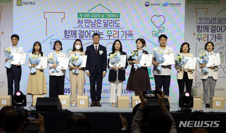 [서울=뉴시스] 조성봉 기자= 지난해 5월11일 오후 서울 용산구 다목적홀 숲에서 열린 2023년 18회 입양의 날 기념행사에서 이기일(왼쪽 네번째)보건복지부 1차관이 유공자들과 기념촬영을 하고 있는 모습. 2023.05.11. suncho21@newsis.com