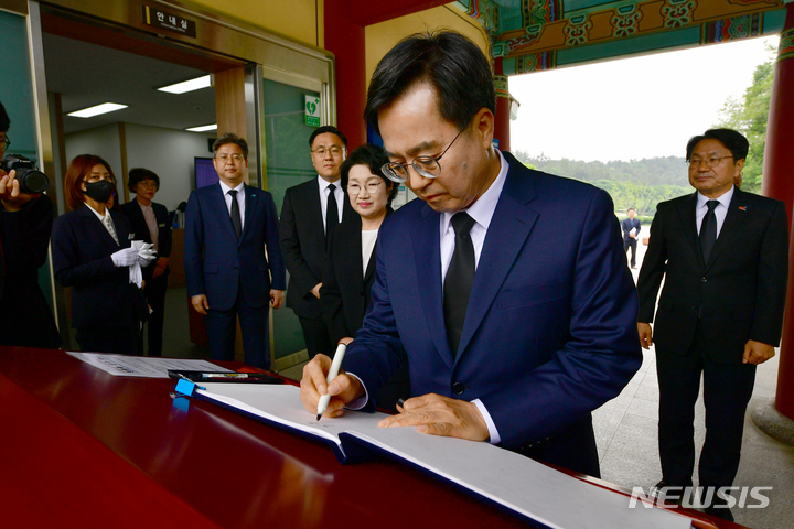 [광주=뉴시스] 이영주 기자 = 김동연 경기도지사가 12일 오전 광주 북구 운정동 국립5·18민주묘지에서 방명록을 쓰고 있다. 2023.05.12. leeyj2578@newsis.com
