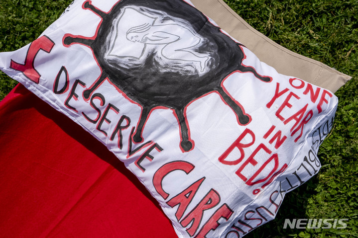 [워싱턴= AP/뉴시스] 올해 5월 12일 워싱턴 시내 내셔널 몰에서 전시된 코로나 19 후유증 환자들의 항의시위용 침상 300개와 베개에 "우리도 치료받을 권리가 있다"&nbsp; "1년째 병상에!" 등의 구호가 적혀있다.&nbsp;&nbsp; 