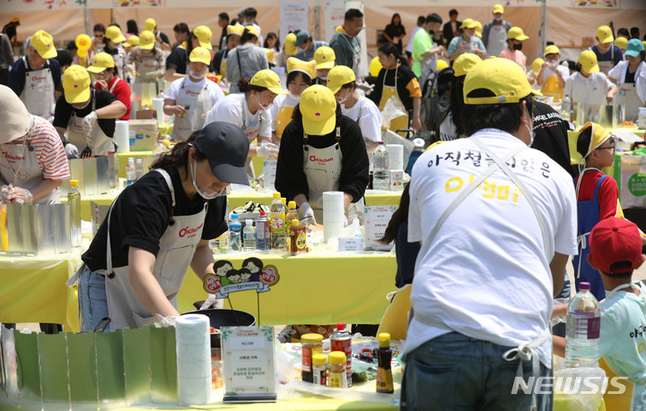 [과천=뉴시스] 조수정 기자 = 13일 경기 과천시 서울랜드 피크닉장에서 열린 '스위트홈 제26회 오뚜기 가족요리 페스티벌'에서 참가 가족들이 요리 실력을 뽐내고 있다. 올해는 지난해보다 참가자 규모를 두배 늘린 총 100팀이 참여해 한식·양식·중식·일식 등 요리 경연을 펼쳤다. 2023.05.13. chocrystal@newsis.com