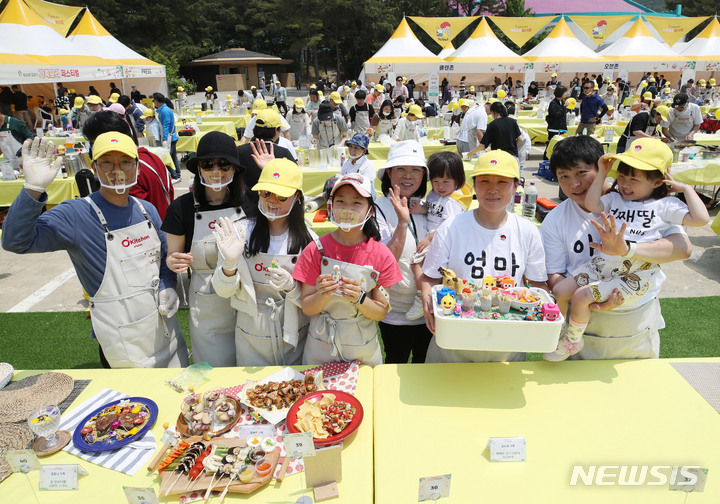[과천=뉴시스] 조수정 기자 = 13일 경기 과천시 서울랜드 피크닉장에서 열린 '스위트홈 제26회 오뚜기 가족요리 페스티벌'에서 참가 가족들이 요리 실력을 뽐내고 있다. 올해는 지난해보다 참가자 규모를 두배 늘린 총 100팀이 참여해 한식·양식·중식·일식 등 요리 경연을 펼쳤다. 2023.05.13. chocrystal@newsis.com