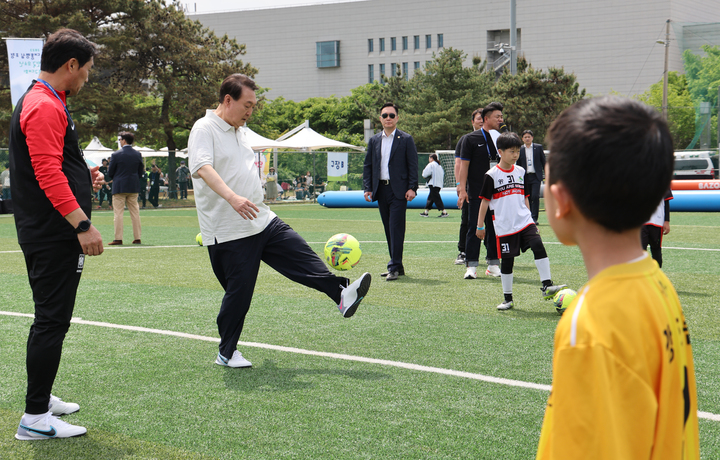 [서울=뉴시스] 전신 기자 = 윤석열 대통령이 14일 서울 용산어린이정원 내 축구장에서 열린 축구 클리닉에서 전국 유소년 축구대회에 참가한 어린이 선수들과 볼 트래핑 대결을 하고 있다. (대통령실통신사진기자단) 2023.05.14. photo1006@newsis.com