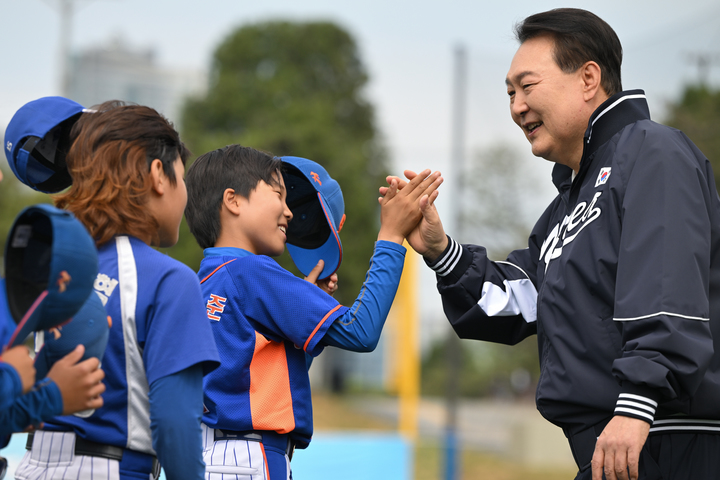 [서울=뉴시스] 윤석열 대통령이 14일 서울 용산어린이정원 내 야구장에서 열린 2023 대통령실 초청 전국 유소년 야구대회 결승 경기에 앞서 선수들과 하이파이브를 하고 있다. (사진=대통령실 제공) 2023.05.14. photo@newsis.com.14