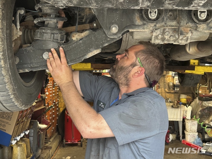 [앤아버(미 미시간주)=AP/뉴시스]미 미시간주 앤아버의 한 자동차 정비업소에서 수리공이 픽업트럭 차량 밑부분을 점검하고 있다. 차량 구매 가격이 고통스러울 정도로 높은데다 잇딴 금리 인상으로 자동차 구입을 위한 대출금의 월 상환액이 더 높아지면서 미국 도로 위를 주행하는 자동차들의 평균 운행 연수가 12.5년으로 사상 최고를 기록한 것으로 'S&P 글로벌 모빌리티'의 데이터에서 나타났다. 2023.05.15 