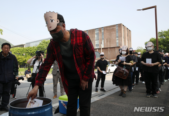 [파주=뉴시스] 고승민 기자 =이우영작가사건대책위원회, 한국만화가협회, 한국웹툰작가협회 회원들이 15일 경기 파주 형설출판사 앞에서 불공정계약 규탄 및 '검정고무신' 장례집회 기자회견을 열고 팬아트를 태우는 영결 퍼포먼스를 하고 있다. 2023.05.15. kkssmm99@newsis.com