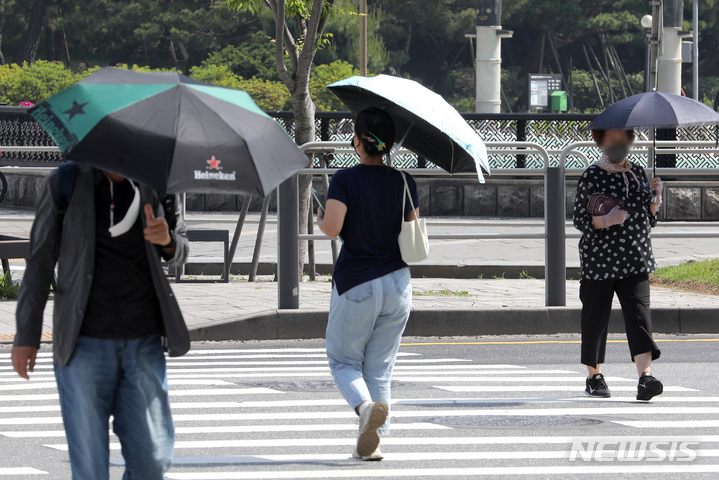 [서울=뉴시스] 조성우 기자 = 서울 낮 최고기온이 30도를 넘는 초여름 날씨를 보인 지난 16일 오후 서울 송파구 거리에서 시민들이 양산을 들고 이동하고 있다. 2023.05.16. xconfind@newsis.com