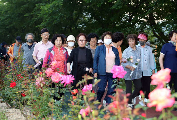 [세종=뉴시스] 밀양무안걷기대회 참가자들이 꽃을 들고 산책로를 걷고 있다. (사진=뉴시스 DB) 2023.07.16. photo@newsis.com *재판매 및 DB 금지