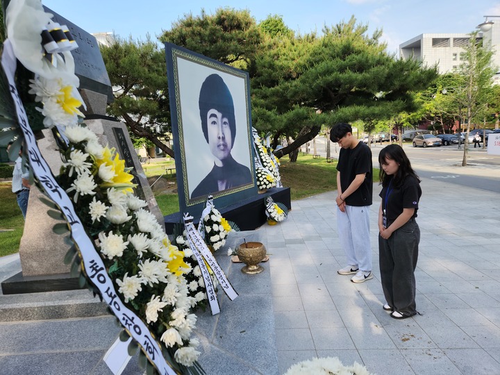 [전주=뉴시스]이동민 기자 = 17일 전북대학교에서 열린 제43주년 5·18민주화운동 전북기념식에서 대학생들이 故이세종 열사 추모비에 헌화하고 있다. *재판매 및 DB 금지