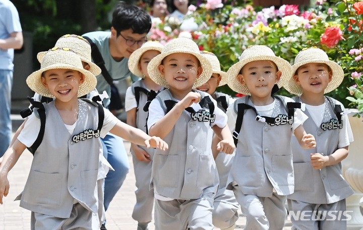 [용인=뉴시스] 김종택 기자 = 석가탄신일을 열흘 앞둔 17일 경기도 용인 에버랜드 장미원을 찾은 조계사 단기 출가 동자승들이 달리기를 하며 즐거워하고 있다. 2023.05.17. jtk@newsis.com