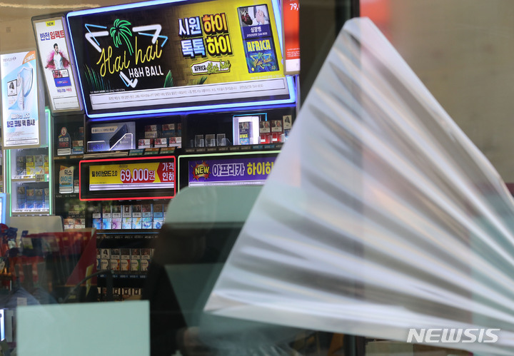 [서울=뉴시스] 권창회 기자 = 17일 오후 서울 시내 편의점에서 관계자가 반투명 시트지를 제거하고 있다. 국무조정실은 이날 편의점 내부 담배광고가 밖에서 보이지 않게끔 붙여놓은 반투명 시트지를 제거하고 금연광고로 대체할 것을 보건복지부 등에 권고했다. 2023.05.17. kch0523@newsis.com