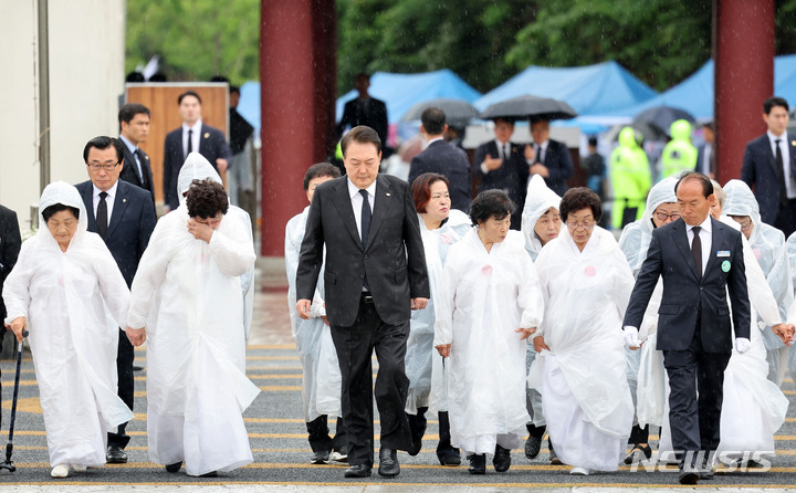 [광주=뉴시스] 홍효식 기자 = 윤석열 대통령이 18일 광주 북구 국립5·18민주묘지에서 열린 제43주년 5·18민주화운동 기념식에 오월어머니회 회원들과 함께 입장하고 있다. (대통령실통신사진기자단) 2023.05.18. yesphoto@newsis.com