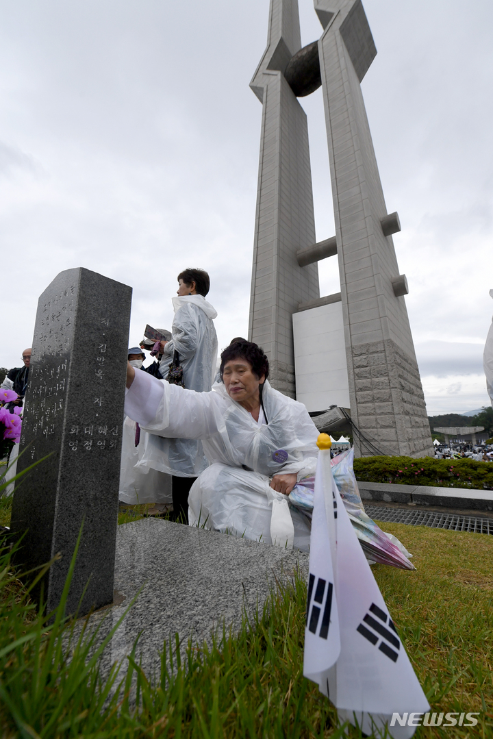 [광주=뉴시스] 김혜인 기자 = 18일 오전 광주 북구 운정동 국립 5·18민주묘지에 고 김안부 열사의 아내가 남편의 묘역을 참배하고 있다. 2023.05.18. hyein0342@newsis.com