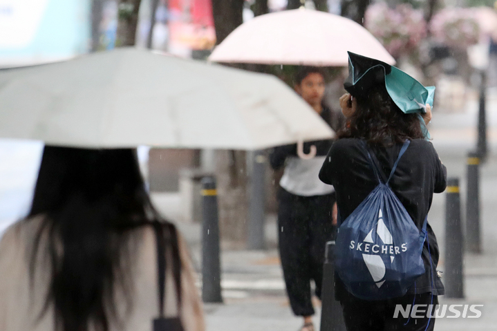 [서울=뉴시스] 조성우 기자 = 비가 내리는 지난 18일 오후 서울 신촌 거리에서 한 시민이 가방을 머리에 쓰고 이동하고 있다. 2023.05.18. xconfind@newsis.com