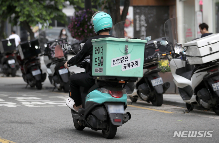 [서울=뉴시스] 조성우 기자 = 지난달 18일 서울 시내에서 배달 노동자가 오토바이를 타고 이동하고 있다. 2023.05.18. xconfind@newsis.com