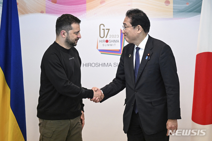 [히로시마=AP/뉴시스] 주요 7개국(G7) 정상회의를 계기로 볼로디미르 젤렌스키 우크라이나 대통령과 기시다 후미오(岸田文雄) 일본 총리가 양자 회담을 가지고 새로운 협력 문서를 체결하는 방향으로 조율하고 있다고 일본 공영 NHK가 7일 보도했다. 사진은 지난해 5월 21일 기시다 총리(오른쪽)가 일본 히로시마에서 열린 G7 정상회의 폐막 후 젤렌스키 대통령과 양자 회담에 앞서 악수를 하고 있는 모습. 2023.06.07.