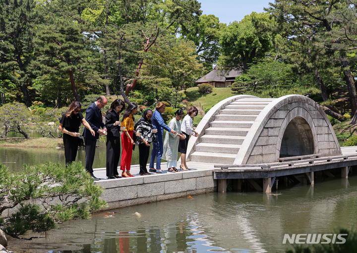 [히로시마=뉴시스] 홍효식 기자 = 윤석열 대통령과 함께 일본을 방문 중인 김건희 여사가 21일 히로시마 슈케이엔에서 열린 G7 정상회의 공식 배우자 프로그램에 참석해 잉어에게 먹이를 주고 있다. 2023.05.21. yesphoto@newsis.com