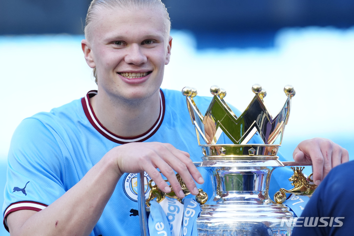 [맨체스터=AP/뉴시스] 맨체스터 시티의 엘링 홀란이 21일(현지시각) 영국 맨체스터의 에티하드 스타디움에서 열린 2022~23 잉글랜드 프로축구 프리미어리그(EPL) 37라운드 첼시와의 경기를 1-0으로 승리한 후 우승을 확정, 트로피를 들고 포즈를 취하고 있다. 맨시티는 전반 12분 훌리안 알바레스의 선제 결승 골로 승리해 승점 88을 기록하며 남은 경기에 상관 없이 우승을 확정했다. 2023.05.22.
