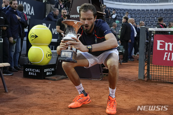 [로마=AP/뉴시스] 다닐 메드베데프(3위·러시아)가 21일(현지시각) 이탈리아 로마에서 열린 남자프로테니스(ATP) 투어 로마 오픈 정상에 올라 트로피를 들면서 장난스레 힘든 표정을 짓고 있다. 메드베데프는 결승에서 홀게르 루네(7위·덴마크)를 2-0(7-5 7-5)으로 꺾고 올해 다섯 번째 우승과 클레이 코트 첫 우승 기록을 세웠다. 2023.05.22.