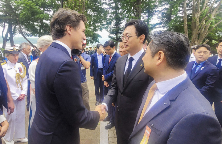 [서울=뉴시스] 지난 18일 경기도 가평군 참전비 경내에서 열린 '캐나다 참전 가평전투지 숲길 조성' 기념식에서쥐스탱 트뤼도 캐나다 총리와 이동훈 아워홈 부사장(가운데)이 인사를 나누고 있다.(사진=아워홈 제공)2023.05.22.