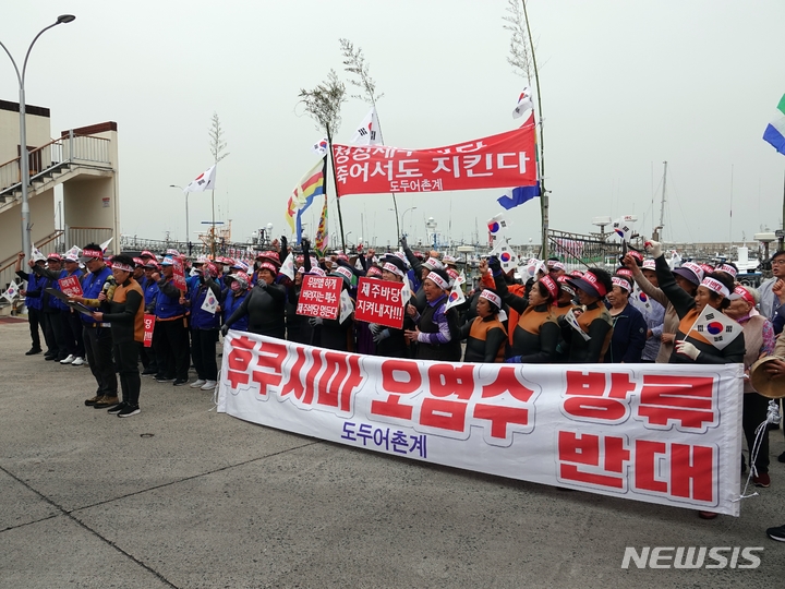 [제주=뉴시스] 오영재 기자 = 22일 오전 제주시 도두항에서 도두 해녀와 어부들이 후쿠시마 원자력발전소 오염수 방류 중단을 촉구하는 기자회견을 하고 있다. 2023.05.22. oyj4343@newsis.com