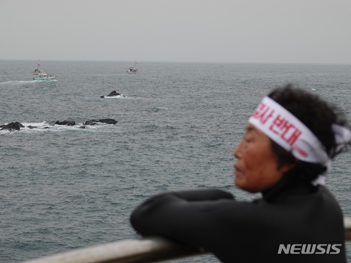 [제주=뉴시스] 오영재 기자 = 22일 오전 제주시 도두동 해상에서 해녀가 후쿠시마 원자력발전소 오염수 방류 중단을 촉구하는 해상시위를 보고 있다. 2023.05.22. oyj4343@newsis.com