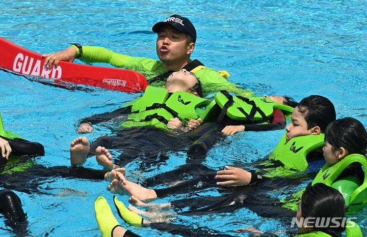 [시흥=뉴시스] 김종택 기자 = 22일 경기도 시흥시 정왕동 거북섬 웨이브파크 파도 풀에서 학생들이 생존수영 실기교육을 받고 있다. 2023.05.22. jtk@newsis.com