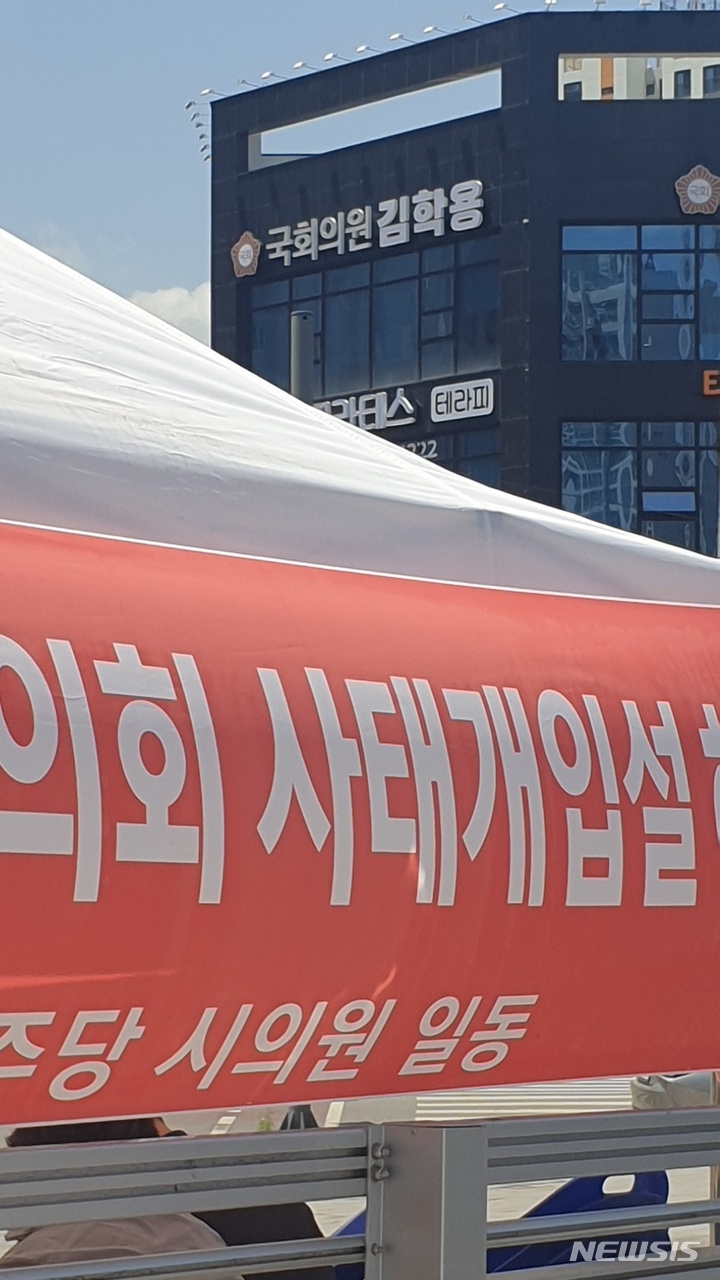 [안성=뉴시스] 안성시의회 더불어민주당 장외농성장 뒤로 국민의힘 김학용 국회의원 사무실이 간판이 보이고 있다. 