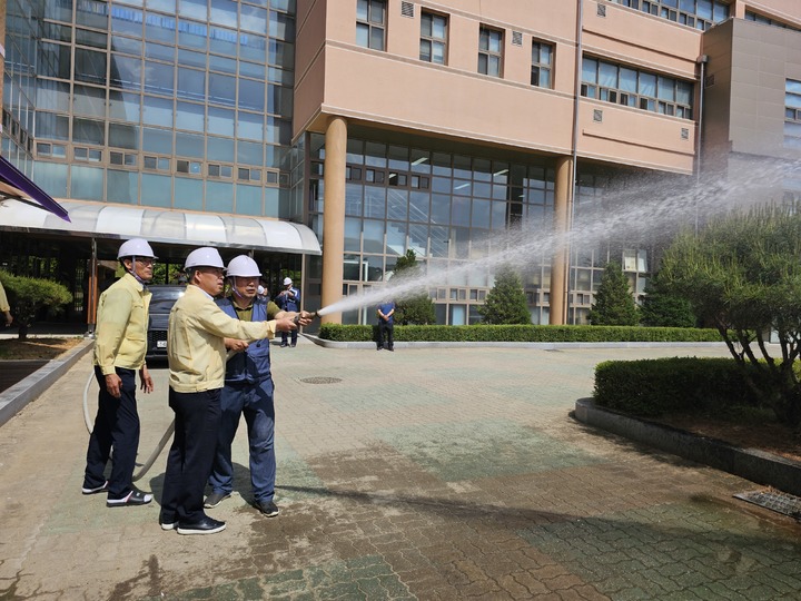 천범산 충북도교육청 부교육감(가운데)이 23일 학교시설 안전 점검차 청원고등학교를 찾아 소방호스로 물을 뿌리고 있다.(사진=충북교육청 제공)2023.05.23.kipoi@newsis.com *재판매 및 DB 금지