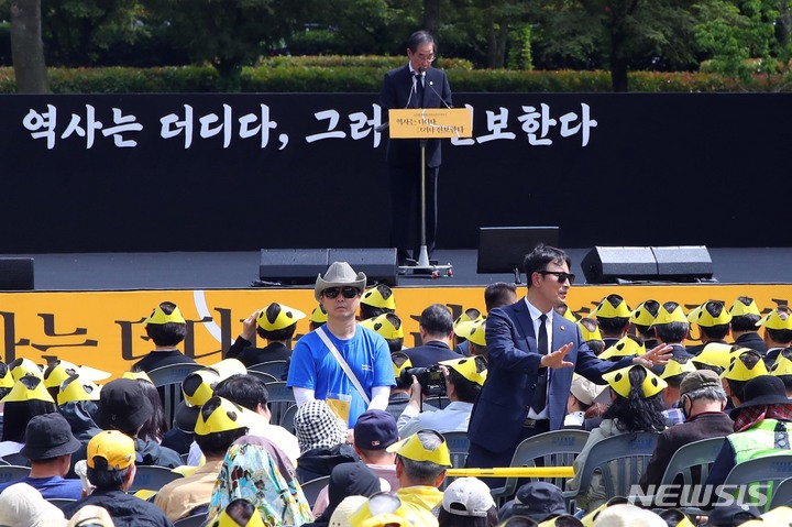 [김해=뉴시스] 차용현 기자 = 23일 오후 경남 김해시 진영읍 봉하마을에서 열린 고 노무현 대통령 14주기 추도식에서 한덕수 국무총리가 추도사를 하는 중 참석한 추도객들이 '내려가라' 등 고함을 지르자 관계자가 손을 들며 자제를 요청하고 있다. (공동취재사진) 2023.05.23. photo@newsis.com