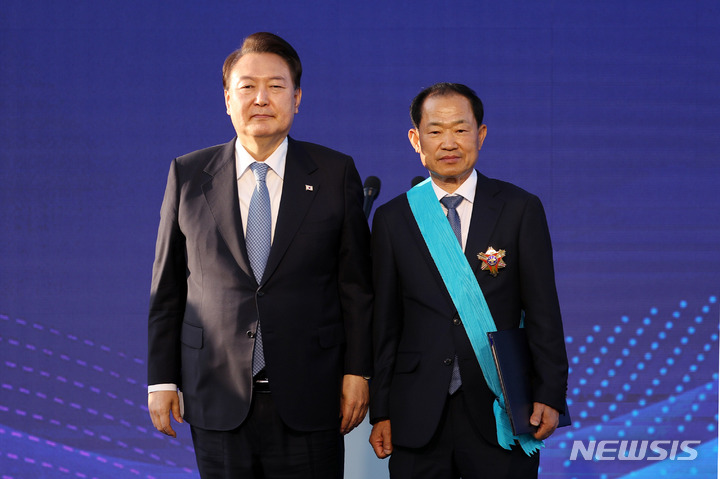 [서울=뉴시스] 홍효식 기자 = 윤석열 대통령이 23일 서울 용산 대통령실 청사 앞 잔디마당에서 열린 2023 대한민국 중소기업인대회에서 고석재 경진단조 대표이사에게 금탑산업훈장을 수여한 뒤 기념촬영하고 있다. 2023.05.23. yesphoto@newsis.com
