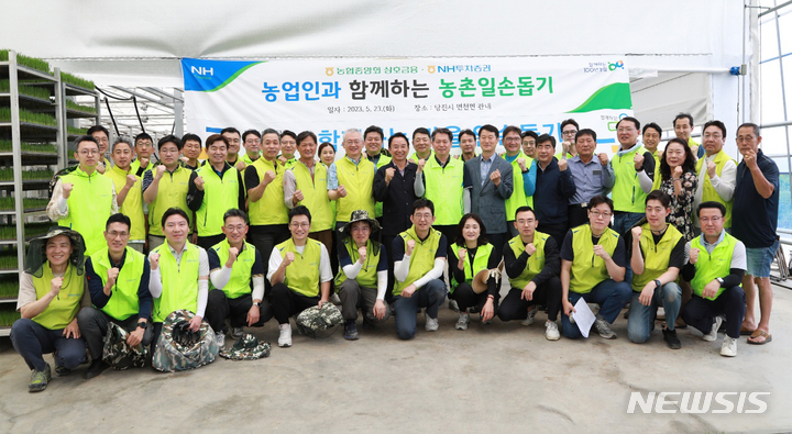 NH투자증권이 23일 충남 당진 문봉리 마을에서 일손 돕기 봉사활동을 진행했다. 정영채 사장(두번째줄 왼쪽 일곱번째)와 조소행 상호금융 대표(두번째줄 왼쪽 아홉번째) 등 임직원들이 벼 육묘 경화 작업 후 기념 촬영을 하고있다. (사진제공=NH투자증권) *재판매 및 DB 금지