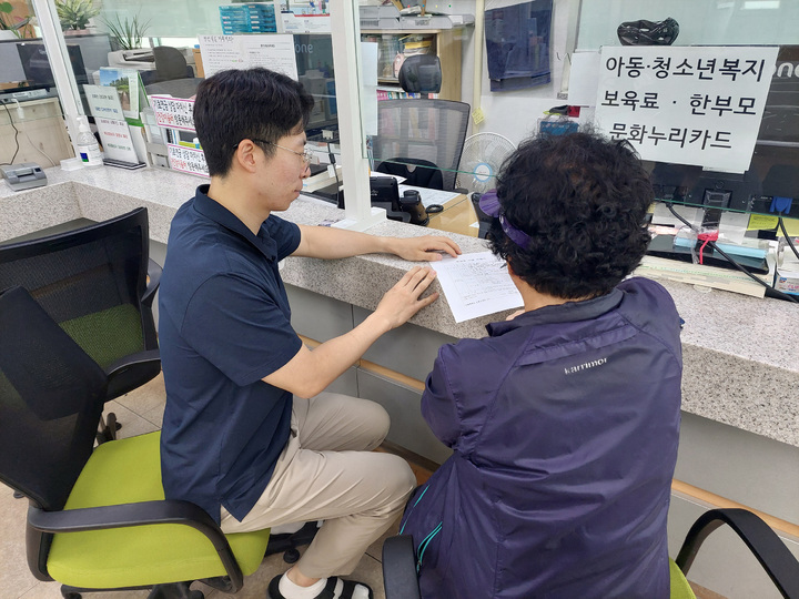 [서울=뉴시스]도봉구민이 동주민센터 직원의 도움을 받아 위기가구 발견 신고서를 작성하고 있다.(사진=도봉구 제공) *재판매 및 DB 금지