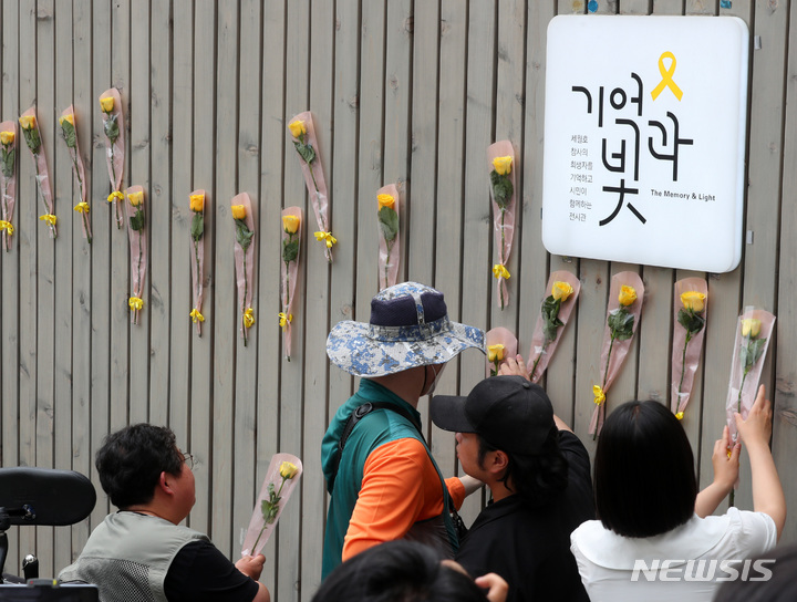 [서울=뉴시스] 배훈식 기자 = 4.16 세월호 참사 10주기 위원회 참여자들이 24일 오후 서울 중구 세월호 기억공간에 노란꽃을 붙이고 있다. 2023.05.24. dahora83@newsis.com