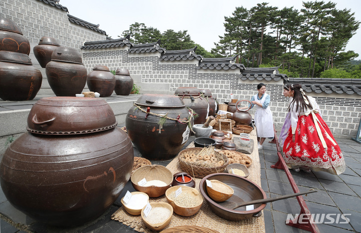 [서울=뉴시스] 김진아 기자 = 24일 서울 경복궁을 찾은 관람객들이 관계자의 설명을 들으며 경복궁 장독을 살펴보고 있다. 문화재청 궁능유적본부 경복궁관리소는 이날부터 6월6일까지 2주간 경복궁 장고를 관람객에게 개방한다. 2023.05.24. bluesoda@newsis.com