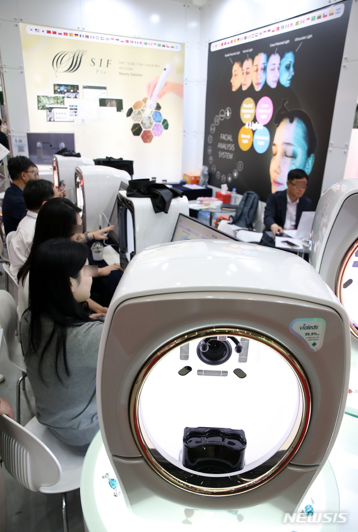 [서울=뉴시스] 고승민 기자 = 지난 2023년 5월 25일 서울 코엑스에서 열린 2023 제37회 서울국제화장품미용산업박람회, 국제건강산업박람회(헬스앤뷰티위크)를 찾은 관람객들이 피부 분석 장치를 체험하고 있다. (해당 사진은 기사와 직접 관련이 없습니다.) 2023.05.25. kkssmm99@newsis.com