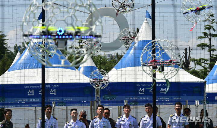 [대구=뉴시스] 이무열 기자 = 25일 오전 대구 육군 제2작전사 대연병장에서 열린 ‘제1회 2작전사령관배 드론봇 전투경연대회’에서 드론 축구에 참가한 육군 3사관학교 생도들이 공중에 매달린 둥근 골대에 드론을 넣기 위해 컨트롤에 집중하고 있다. 2023.05.25. lmy@newsis.com