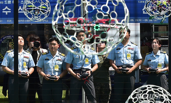 [대구=뉴시스] 이무열 기자 = 25일 오전 대구 육군 제2작전사 대연병장에서 열린 ‘제1회 2작전사령관배 드론봇 전투경연대회’에서 드론 축구에 참가한 육군 3사관학교 생도들이 공중에 매달린 둥근 골대에 드론을 넣기 위해 컨트롤에 집중하고 있다. 2023.05.25. lmy@newsis.com